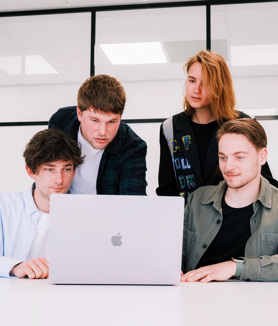 Het team van Digital KISS vergadert rond de laptop van Sam