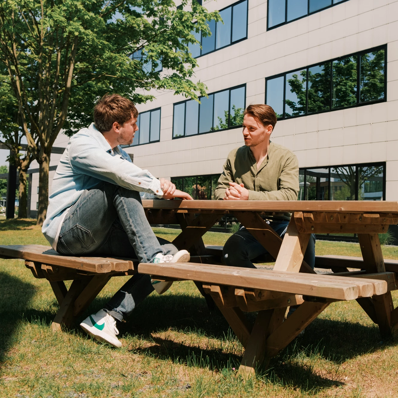 Sam en Leendert zitten buiten aan een picknicktafel te overleggen